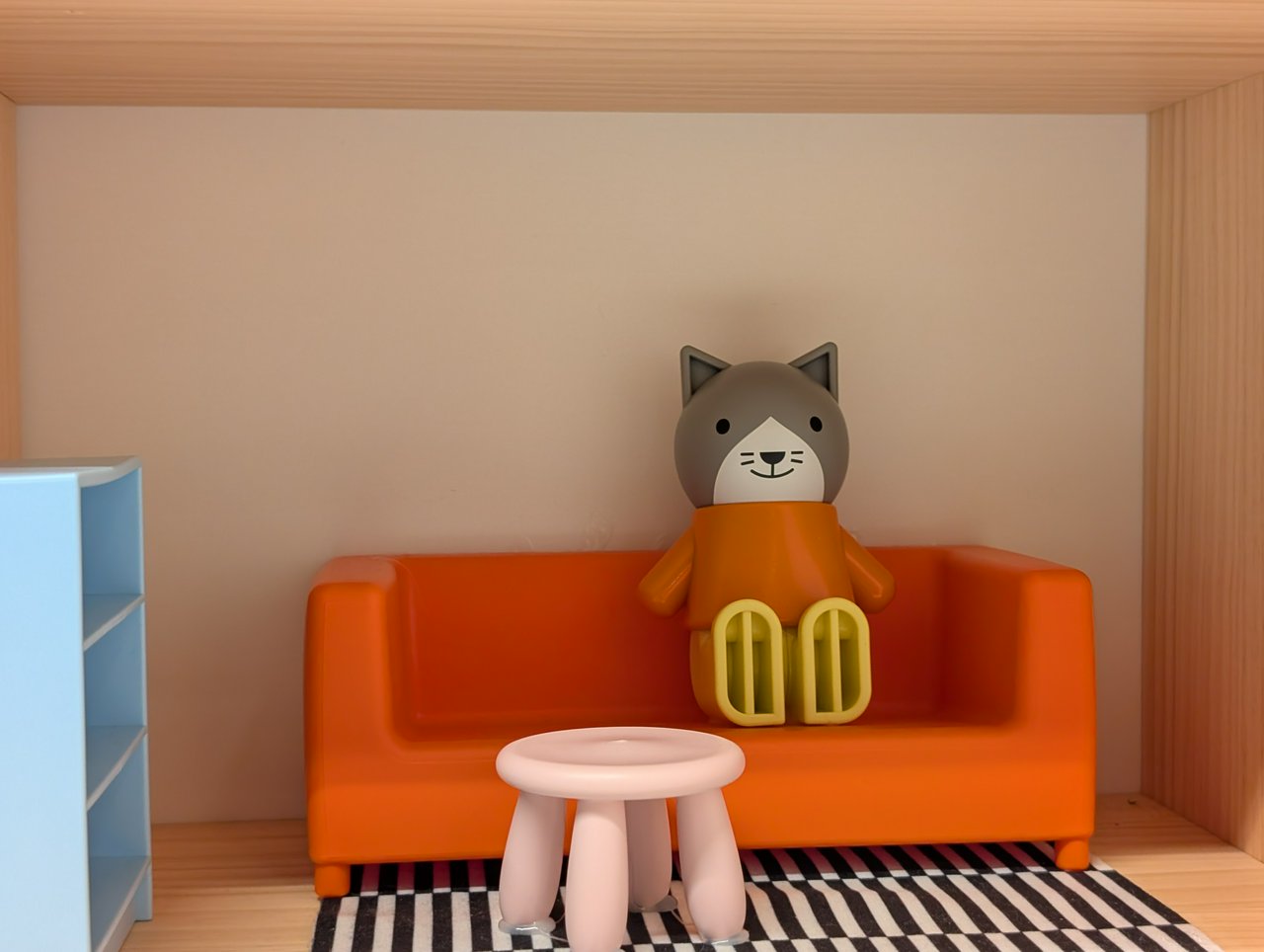 A toy cat in their toy house.