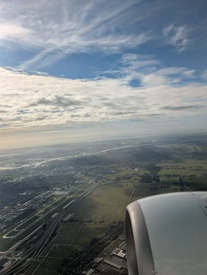 Thumbnail of a photo taken from an airplane window, looking down at the airport below.