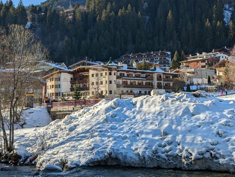 A river, a pile of snow discarded from the street and our hotel in the distance