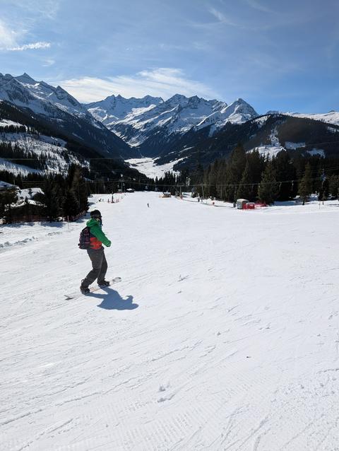 Looking down a slope, a snowboarder happened to ski by.