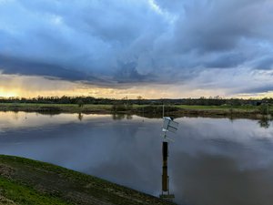 Bad weather looming on the horizon, while the sun sets over the IJssel river.