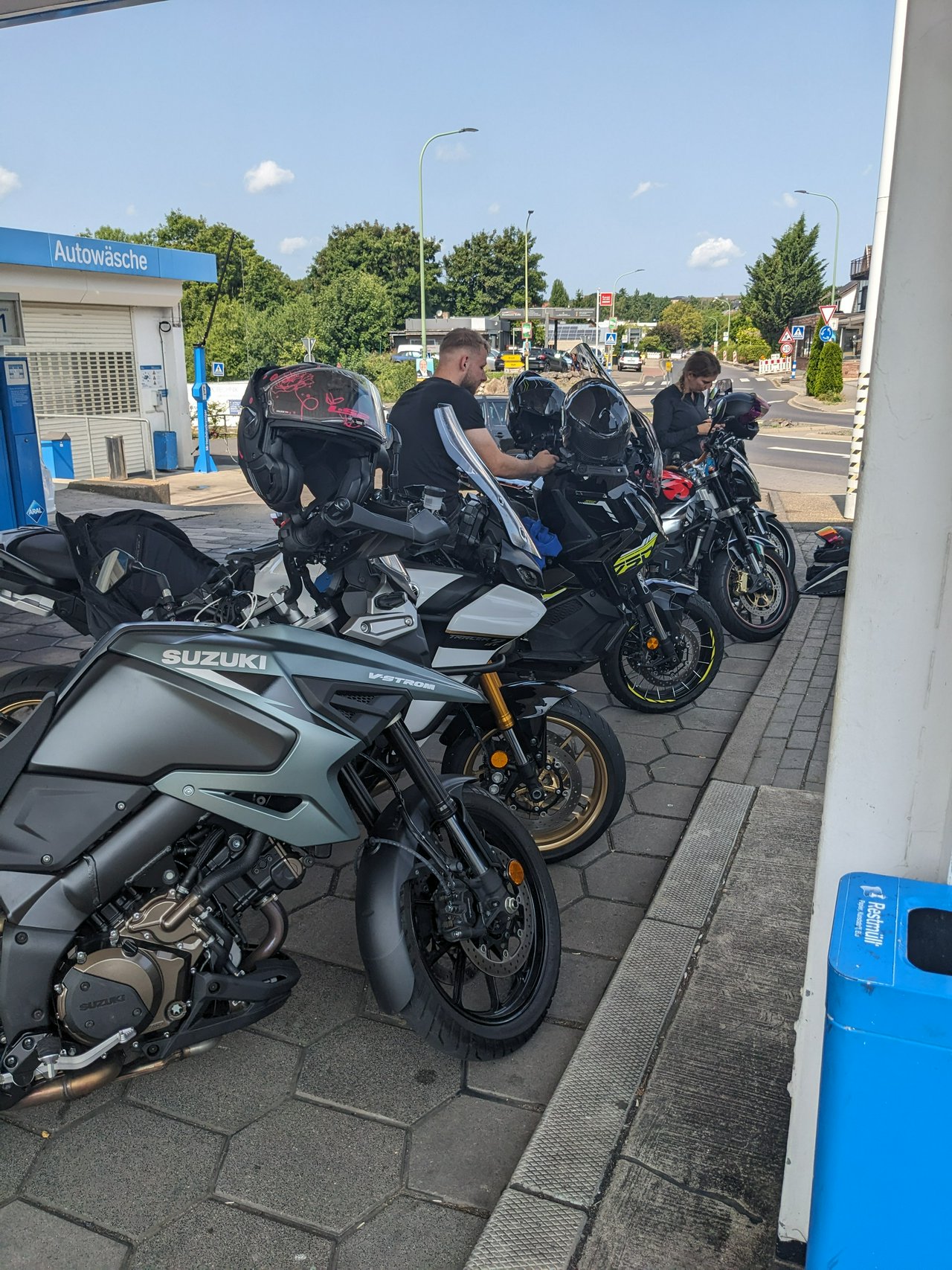 Multiple motorcycles lined up at a gasstation